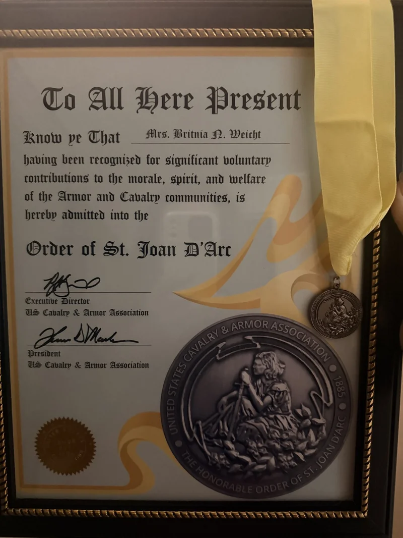 St. Joan D'Arc certificate and medallion awarded to Britnia for dedication to supporting military families